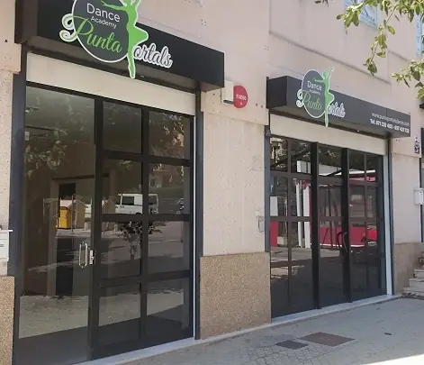 Eingang des Studios Punta Portals Dance mit grünem Logoschild über den Glastüren