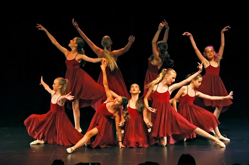 Des danseuses en robes rouges en mousseline forment un tableau dramatique, certaines à genoux, d’autres debout bras levés